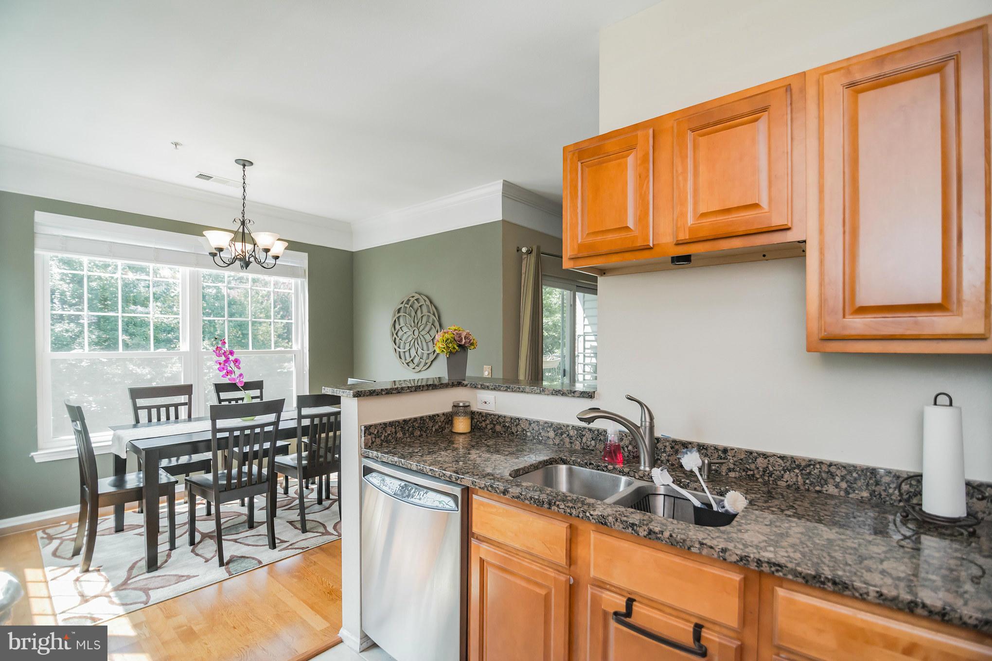 1600 Spring Gate Dr., Unit 2215 McLean, VA 22102 - Photo 17 of 30 a kitchen with stainless steel appliances granite countertop a sink dishwasher and cabinets with wooden floor
