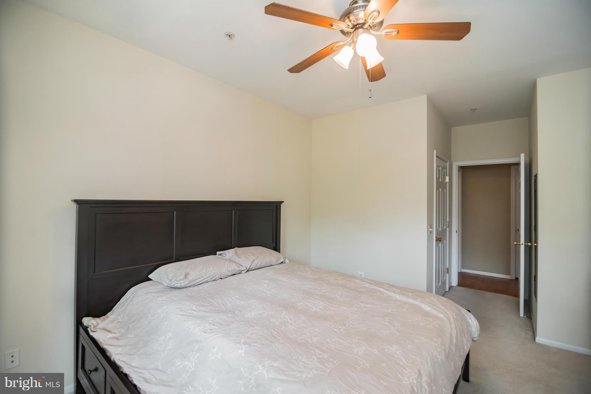1600 Spring Gate Dr., Unit 2215 McLean, VA 22102 - Photo 24 of 30 a bedroom with a bed and a chandelier