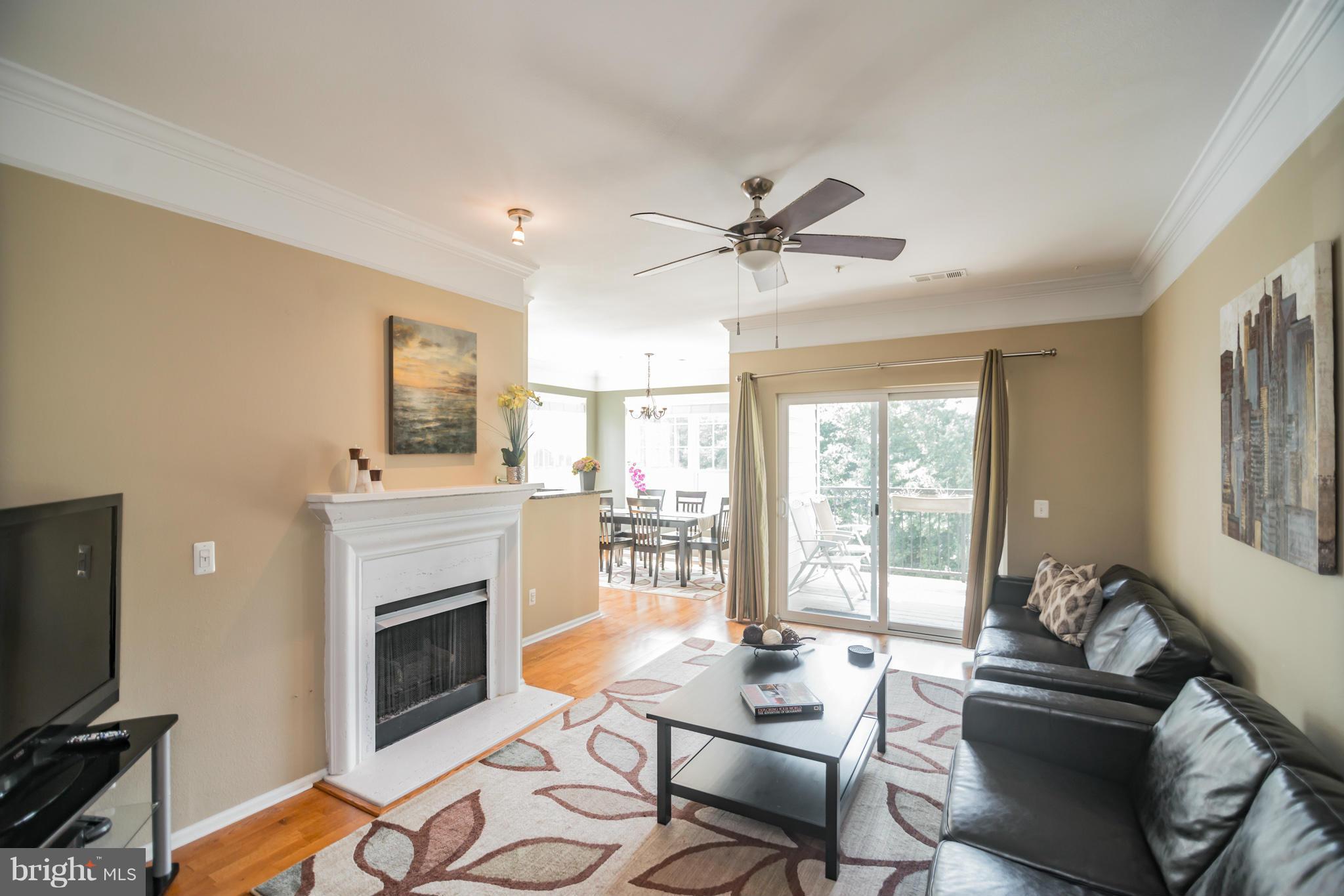 1600 Spring Gate Dr., Unit 2215 McLean, VA 22102 - Photo 6 of 30 a living room with furniture a fireplace and a flat screen tv