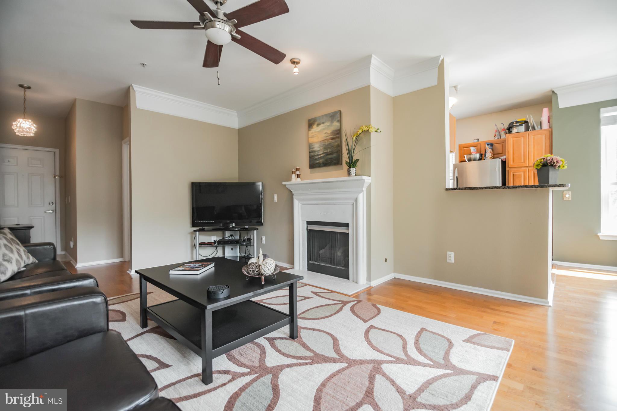 1600 Spring Gate Dr., Unit 2215 McLean, VA 22102 - Photo 7 of 30 a living room with furniture a flat screen tv and a fireplace