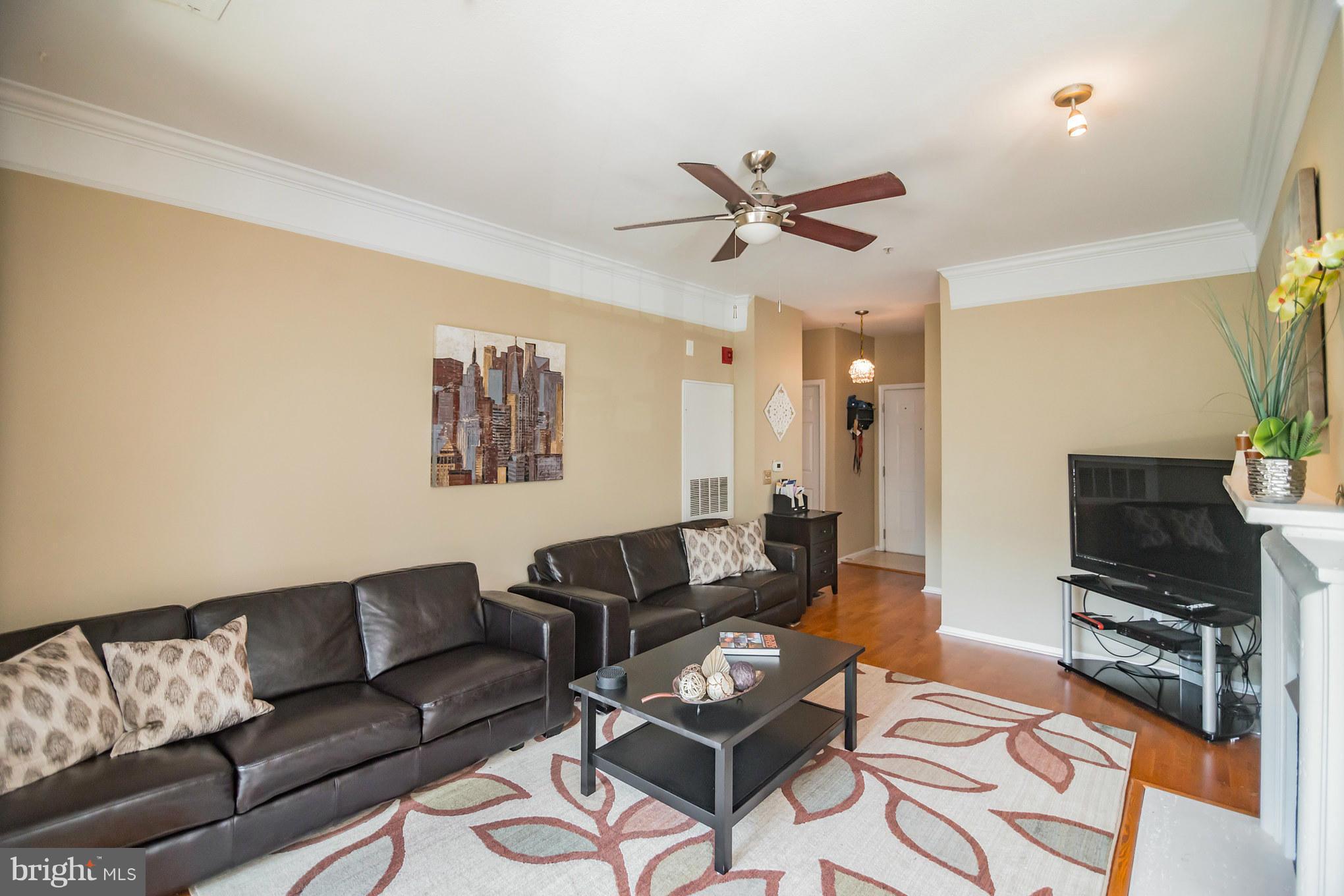 1600 Spring Gate Dr., Unit 2215 McLean, VA 22102 - Photo 10 of 30 a living room with furniture a flat screen tv and a window