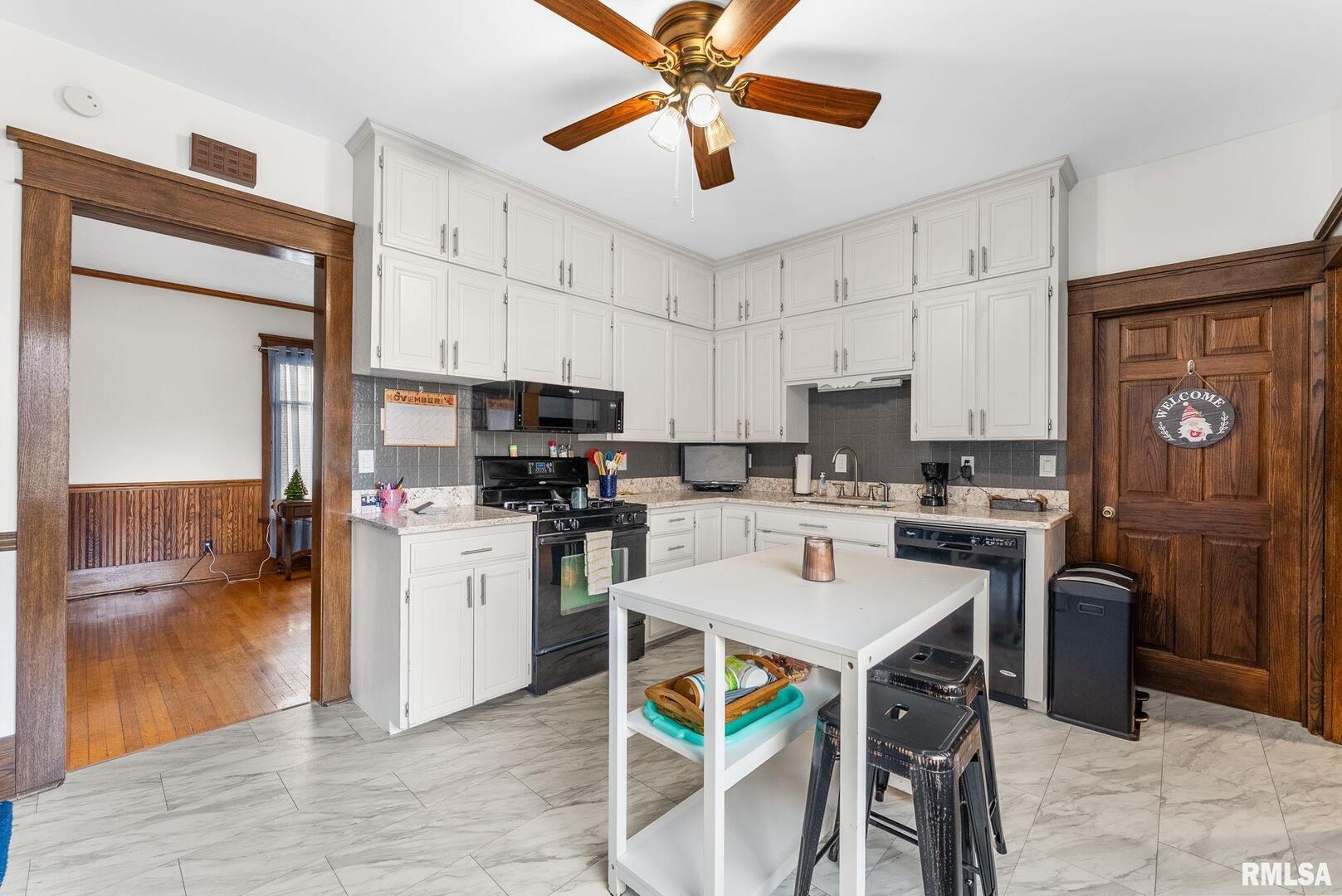 308 Northeast 3rd Avenue Aledo, IL 61231 - Photo 8 of 28 a kitchen with stainless steel appliances kitchen island granite countertop a refrigerator a stove a sink a dining table and chairs with wooden floor