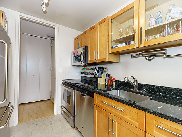 655 West Irving Park Road, Unit 2716 Chicago, IL 60613 - Photo 11 of 25 a kitchen with granite countertop a sink and a refrigerator