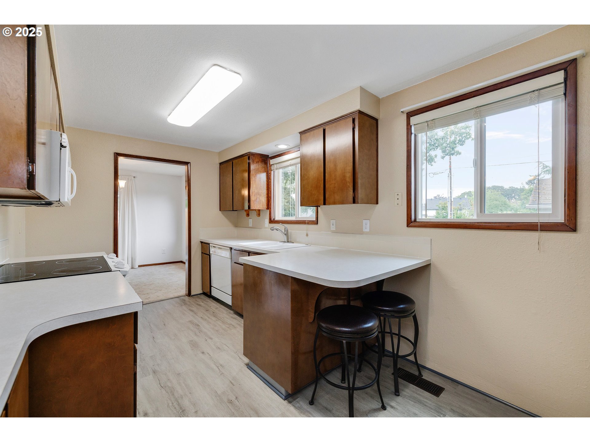 210 Forest Place Forest Grove, OR 97116 - Photo 22 of 35 a open kitchen with stainless steel appliances kitchen island a table chairs in it and wooden floors