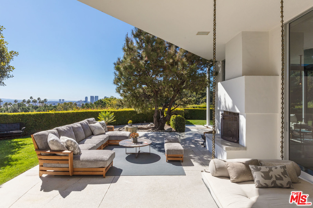 North Hillcrest Road Beverly Hills, CA 90210 - Photo 22 of 34 a view of a patio with couches chairs and a floor to ceiling window