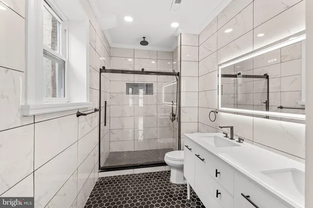a bathroom with a double vanity sink mirror and toilet