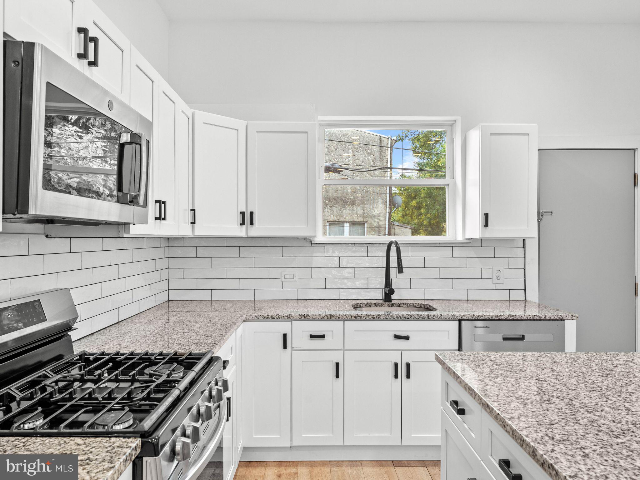 1606 Wharton Street Philadelphia, PA 19146 - Photo 4 of 31 a kitchen with stainless steel appliances granite countertop a stove a sink and a microwave