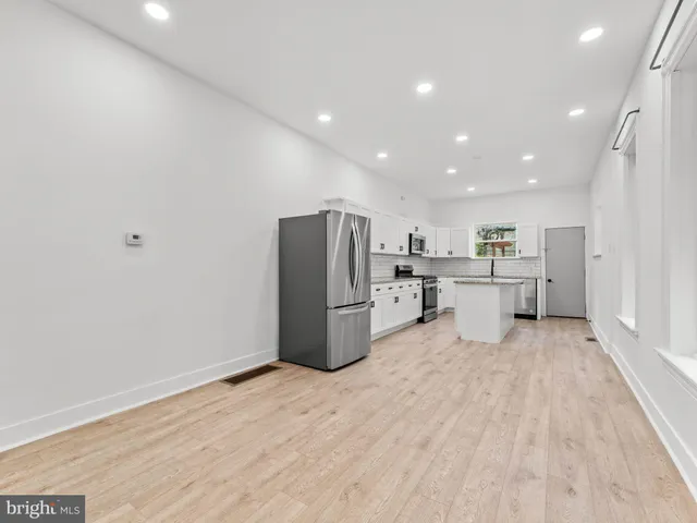 a view of a kitchen with stainless steel appliances a refrigerator and a sink