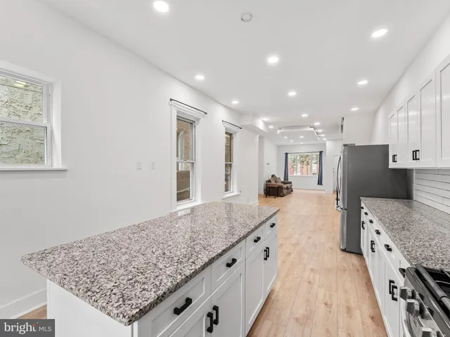 a large kitchen with kitchen island granite countertop a large counter top and stainless steel appliances