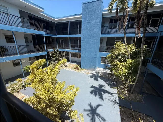 an empty room with wooden floor and a bathroom