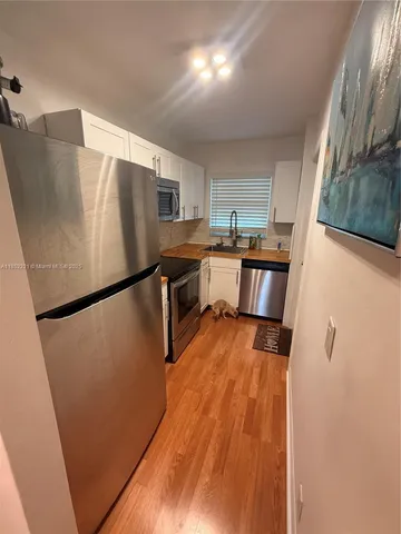 a kitchen with granite countertop a stove sink and microwave