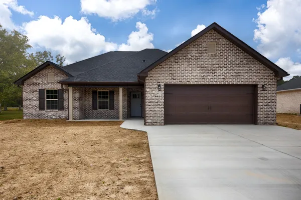 a front view of a house with a garden and yard
