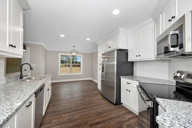 a kitchen with stainless steel appliances granite countertop a sink stove and refrigerator