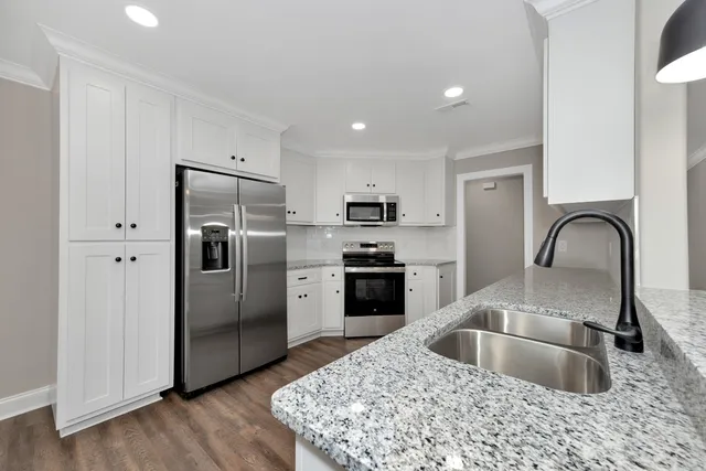 a kitchen with a refrigerator sink and cabinets