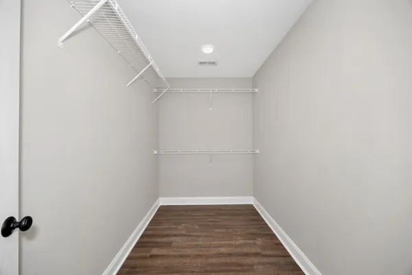 a view of a room with wooden floor and white walls