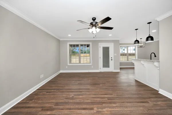 a view of an empty room with window and wooden floor