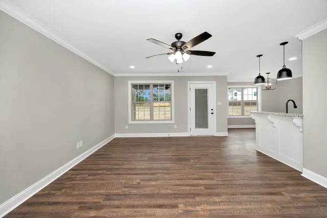 a view of an empty room with window and wooden floor