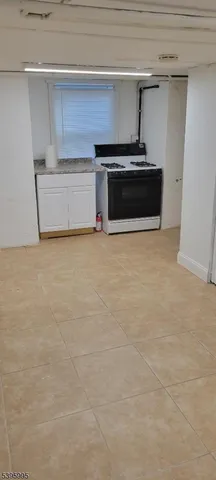 a living room with a stove and a refrigerator
