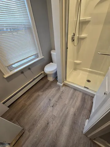 a bathroom with a granite countertop shower and a toilet