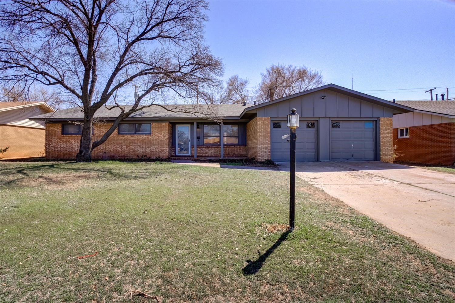 a front view of house with yard and trees around