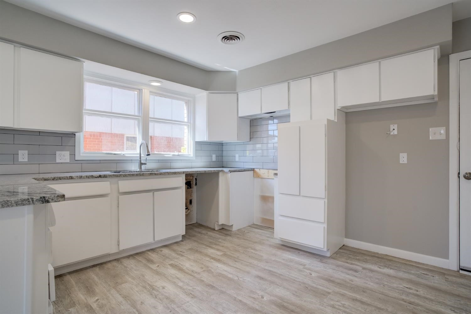 2113 66th Street Lubbock, TX 79412 - Photo 16 of 44 a kitchen with granite countertop white cabinets and white appliances