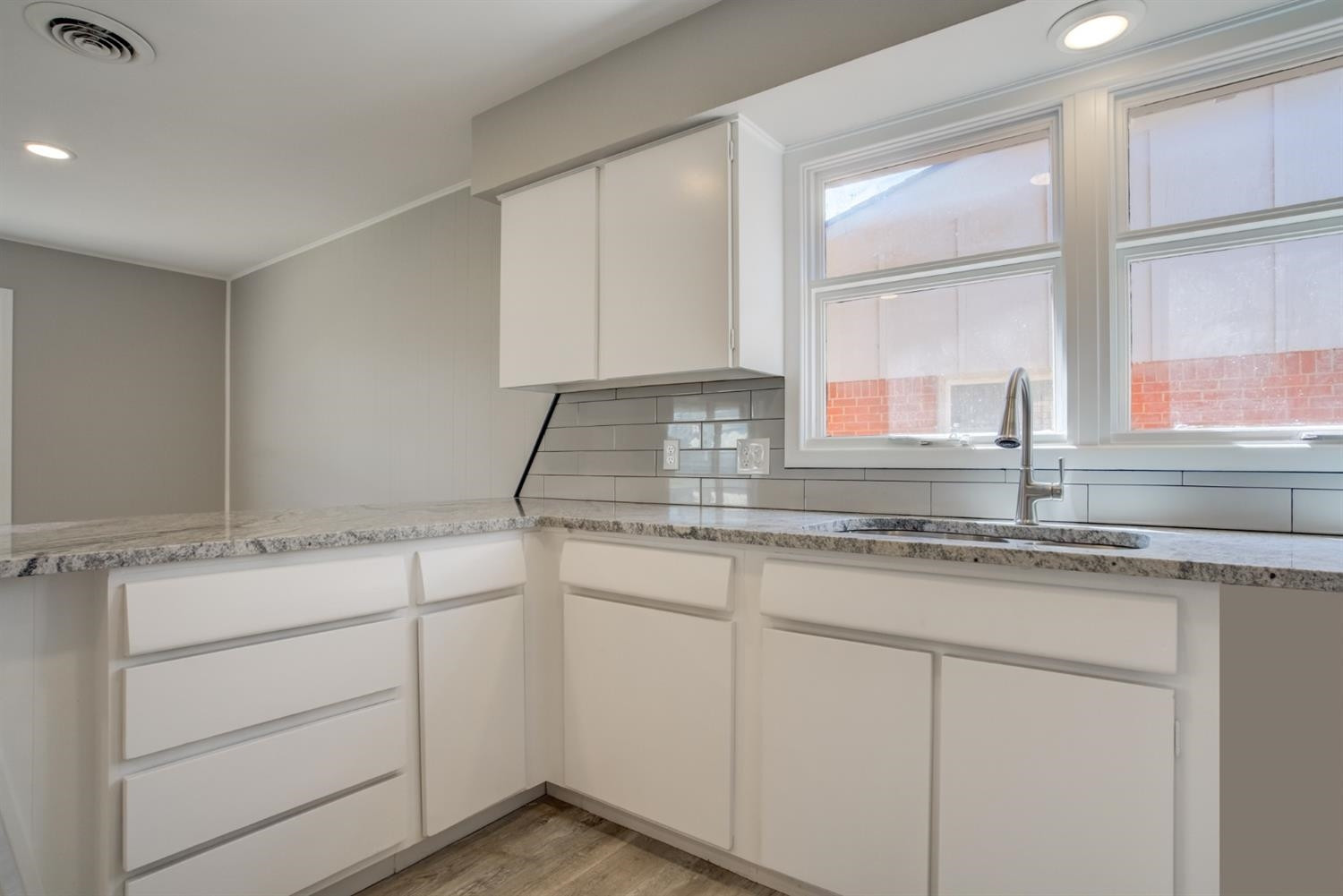 2113 66th Street Lubbock, TX 79412 - Photo 18 of 44 a kitchen with granite countertop white cabinets and white appliances