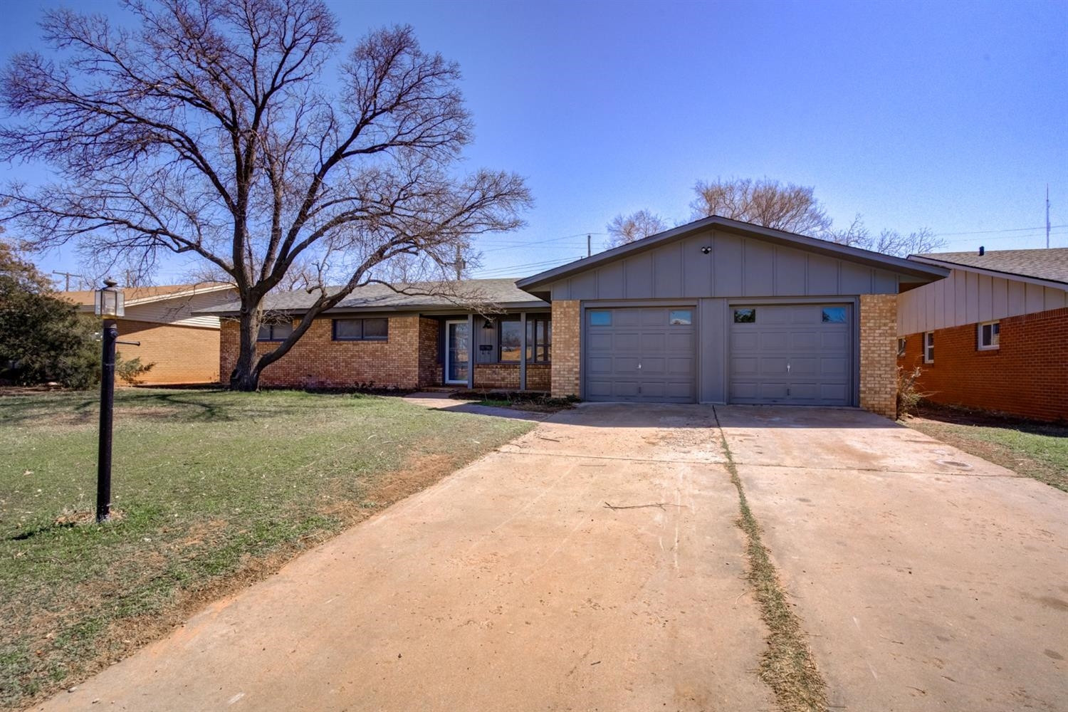 2113 66th Street Lubbock, TX 79412 - Photo 2 of 44 a front view of a house with a yard and garage