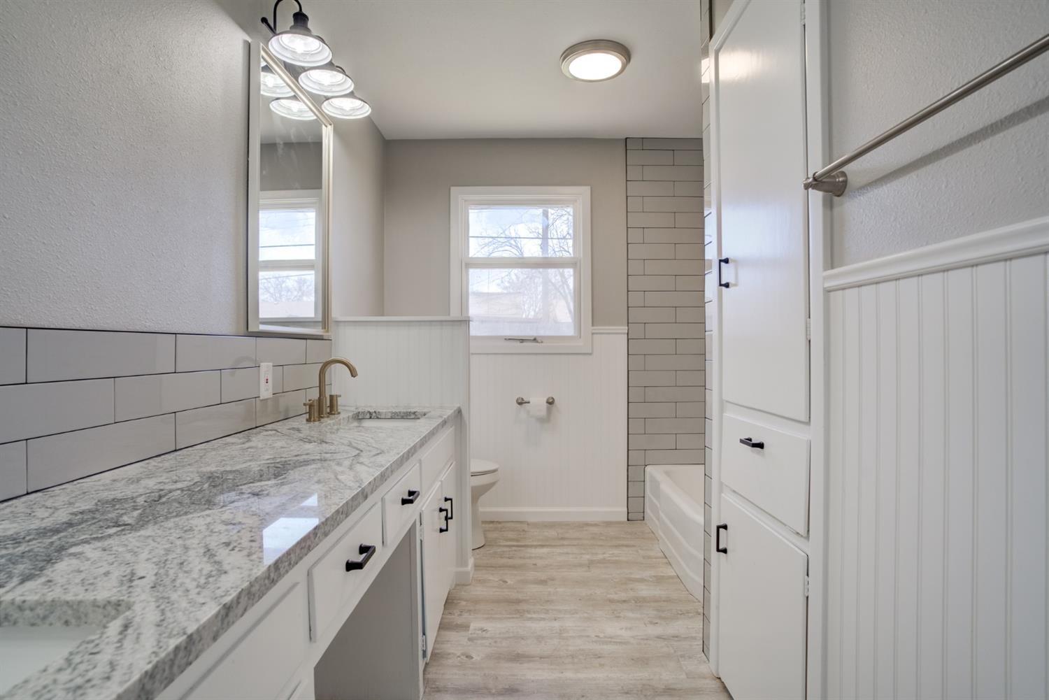 2113 66th Street Lubbock, TX 79412 - Photo 28 of 44 a bathroom with a granite countertop sink a mirror and a shower