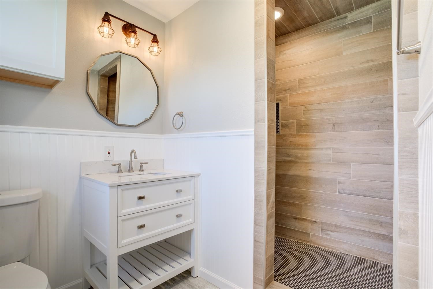 2113 66th Street Lubbock, TX 79412 - Photo 39 of 44 a bathroom with a sink a toilet and a mirror