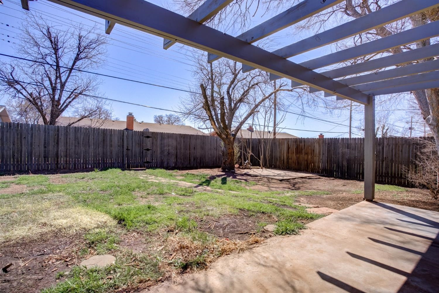 2113 66th Street Lubbock, TX 79412 - Photo 42 of 44 a backyard with wooden fence and a tree