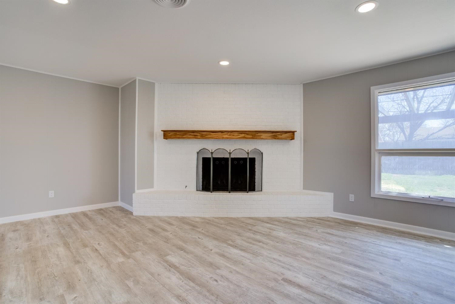 2113 66th Street Lubbock, TX 79412 - Photo 7 of 44 a view of an empty room with a window and a fireplace