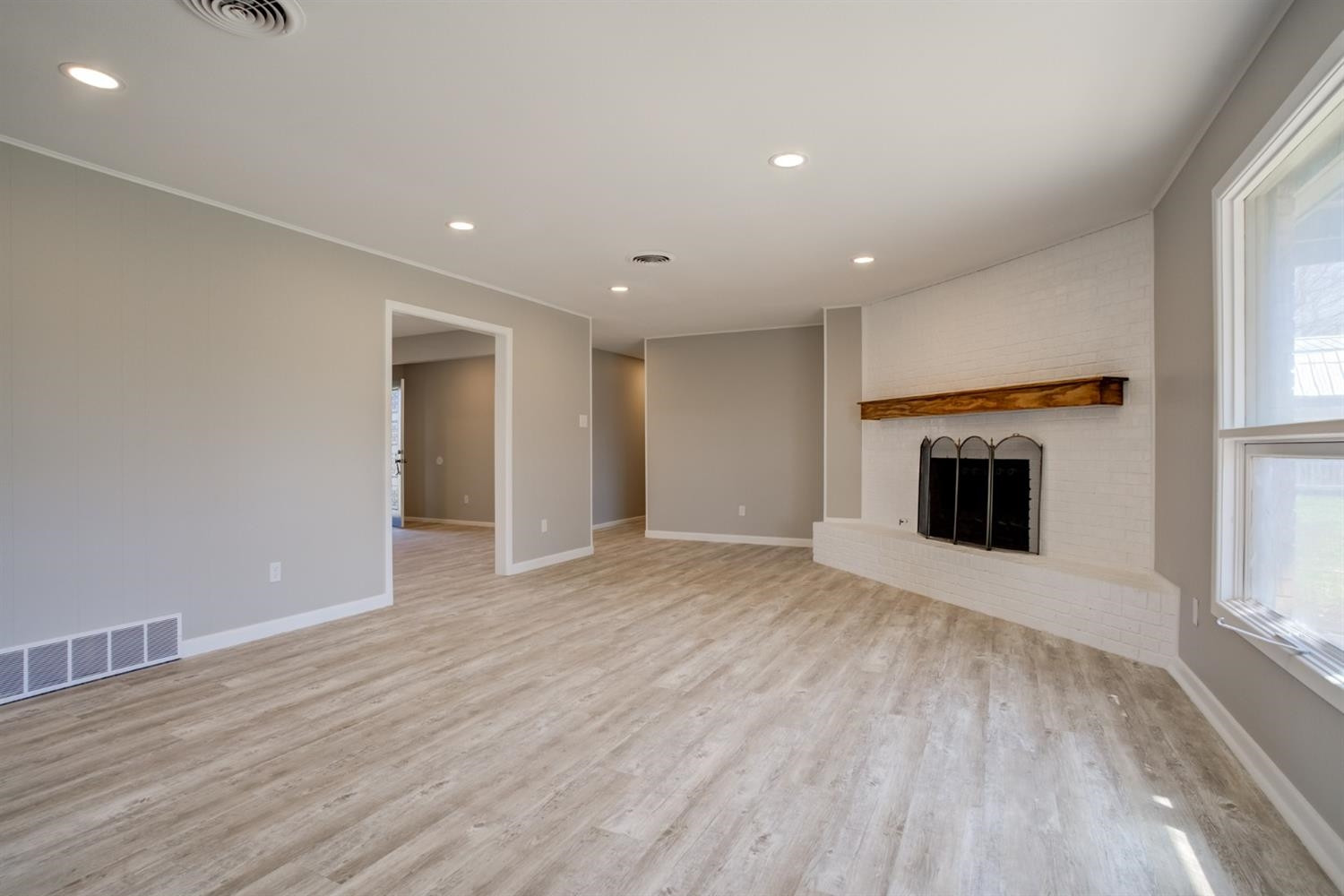 2113 66th Street Lubbock, TX 79412 - Photo 9 of 44 a view of empty room with wooden floor and fireplace