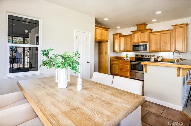 a kitchen with stainless steel appliances kitchen island granite countertop a refrigerator a stove and a sink with wooden floor