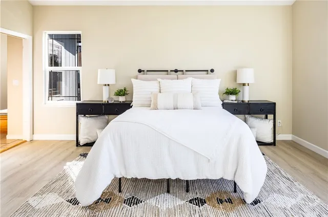 a bed sitting in a bedroom and night stand