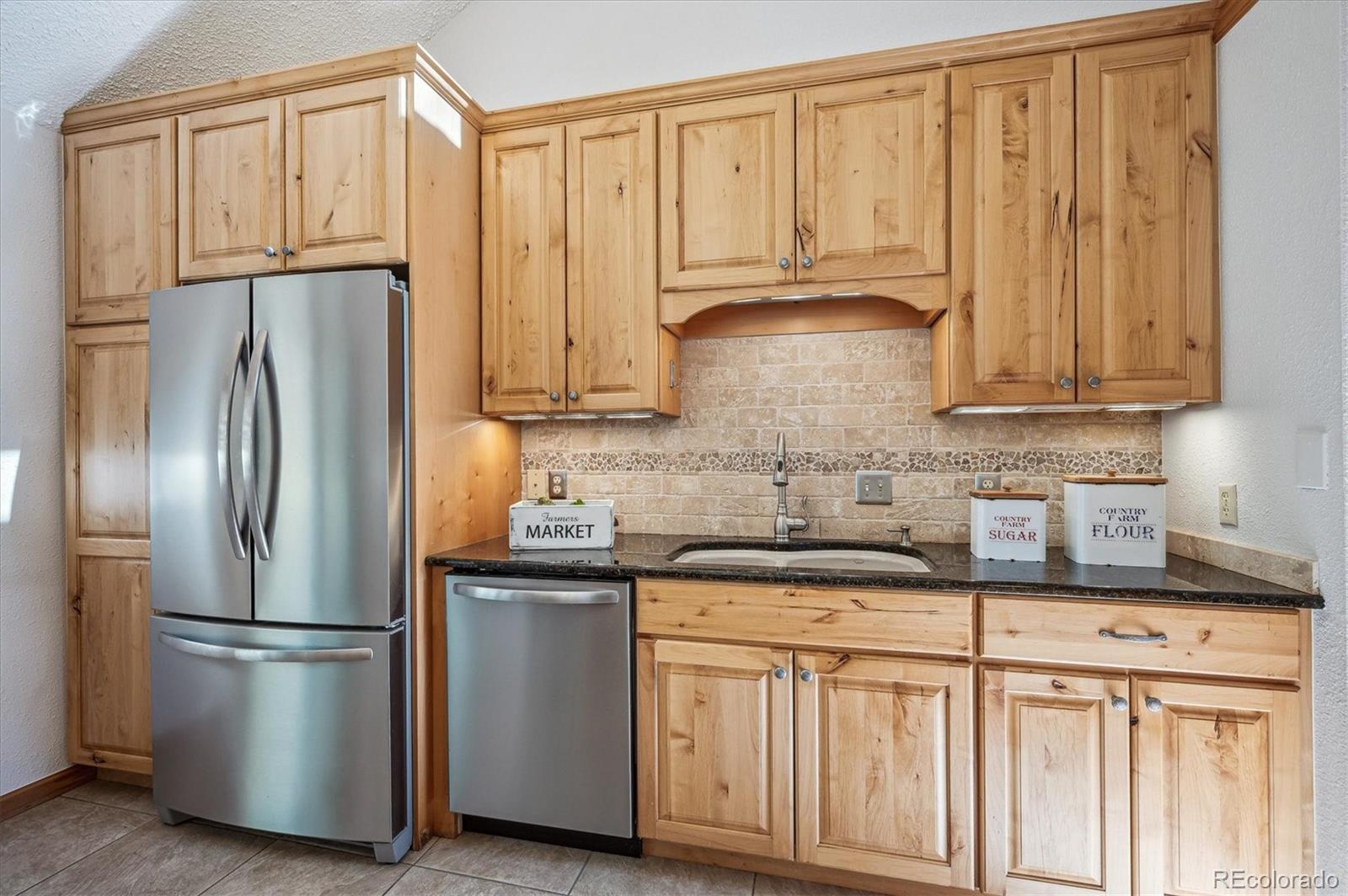 20025 Flint Lane Morrison, CO 80465 - Photo 11 of 35 a kitchen with stainless steel appliances granite countertop a refrigerator sink and cabinets