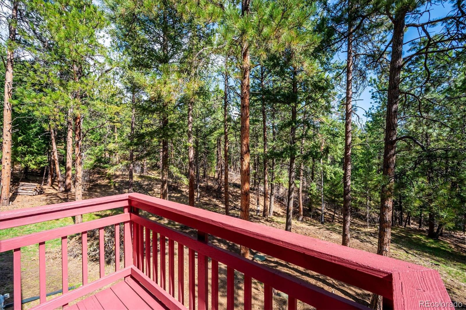 20025 Flint Lane Morrison, CO 80465 - Photo 15 of 35 a view of a roof deck with wooden fence and trees