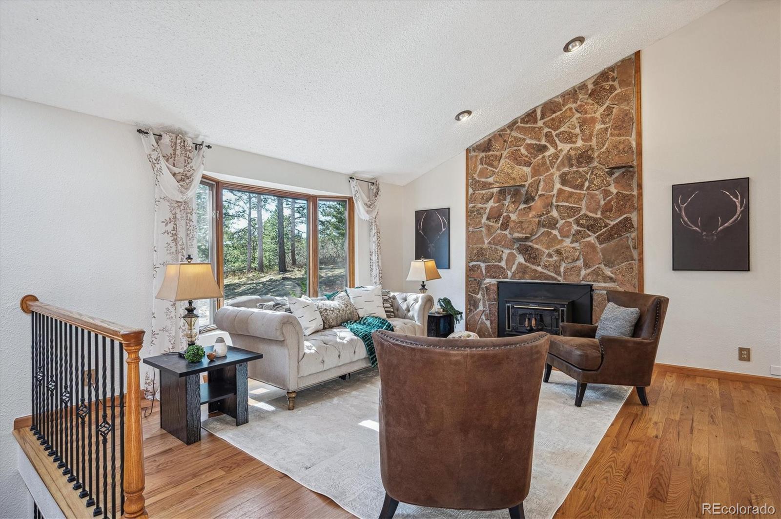 20025 Flint Lane Morrison, CO 80465 - Photo 2 of 35 a living room with furniture a fireplace and a wooden floor
