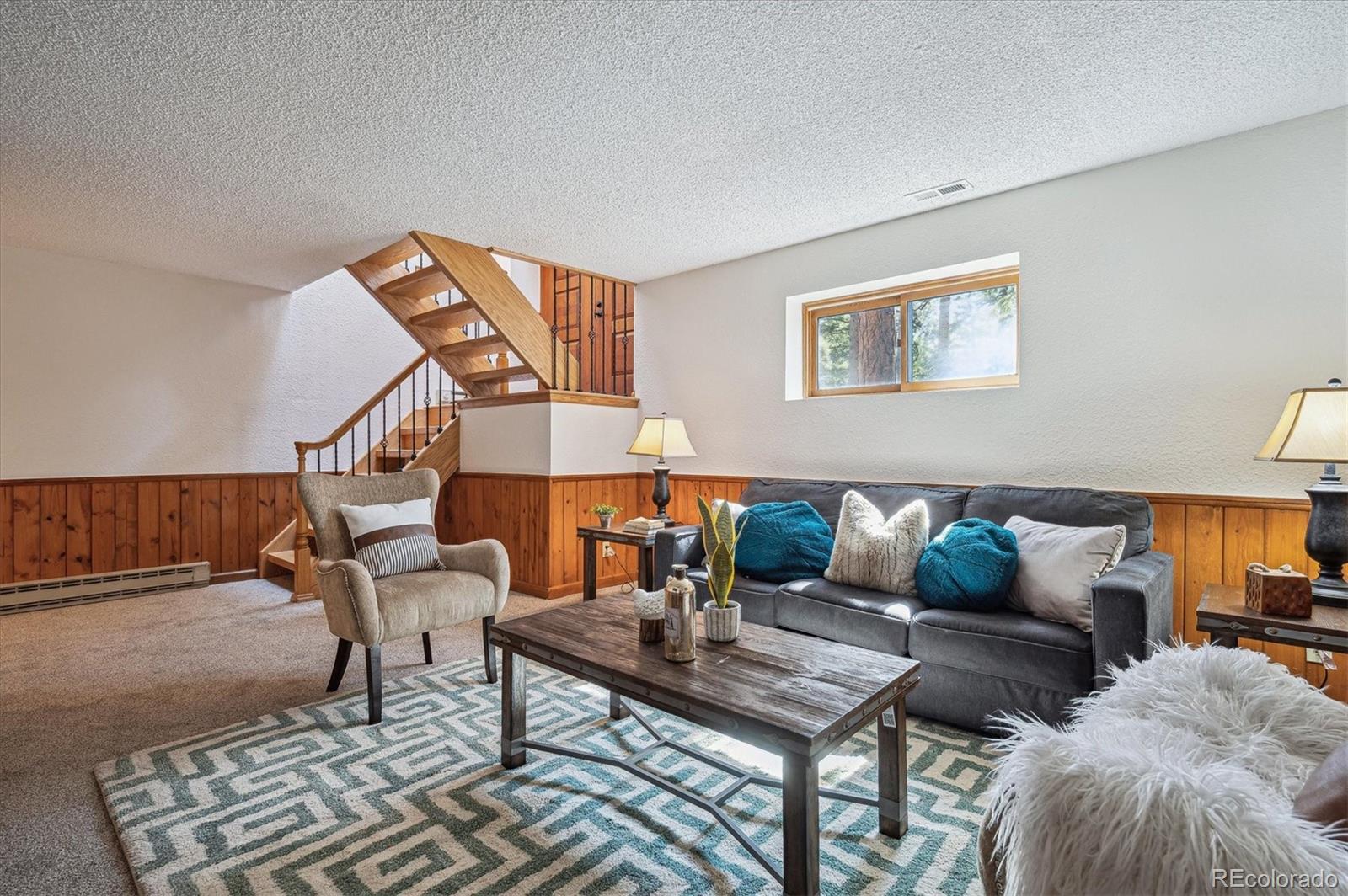 20025 Flint Lane Morrison, CO 80465 - Photo 22 of 35 a living room with furniture and a lamp