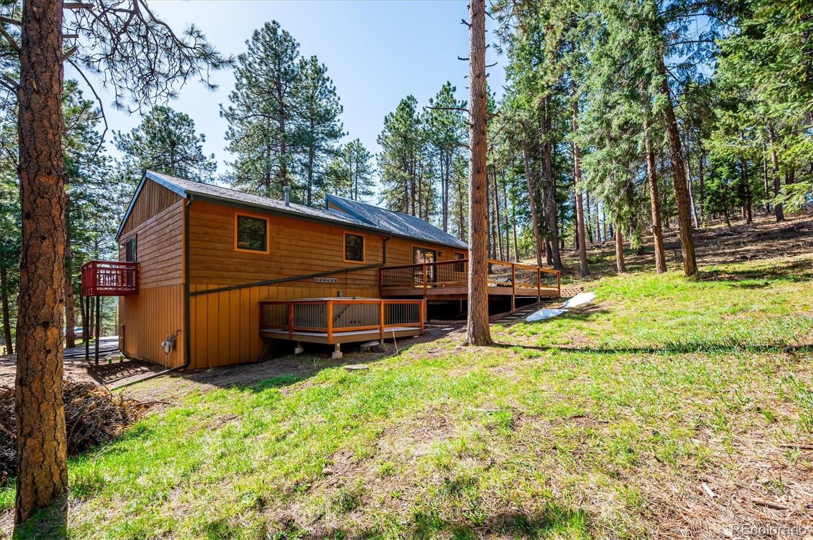 20025 Flint Lane Morrison, CO 80465 - Photo 27 of 35 a view of a house with backyard and trees
