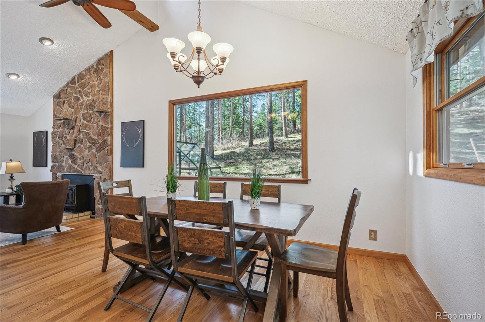 20025 Flint Lane Morrison, CO 80465 - Photo 6 of 35 a view of a dining room with furniture a chandelier and wooden floor
