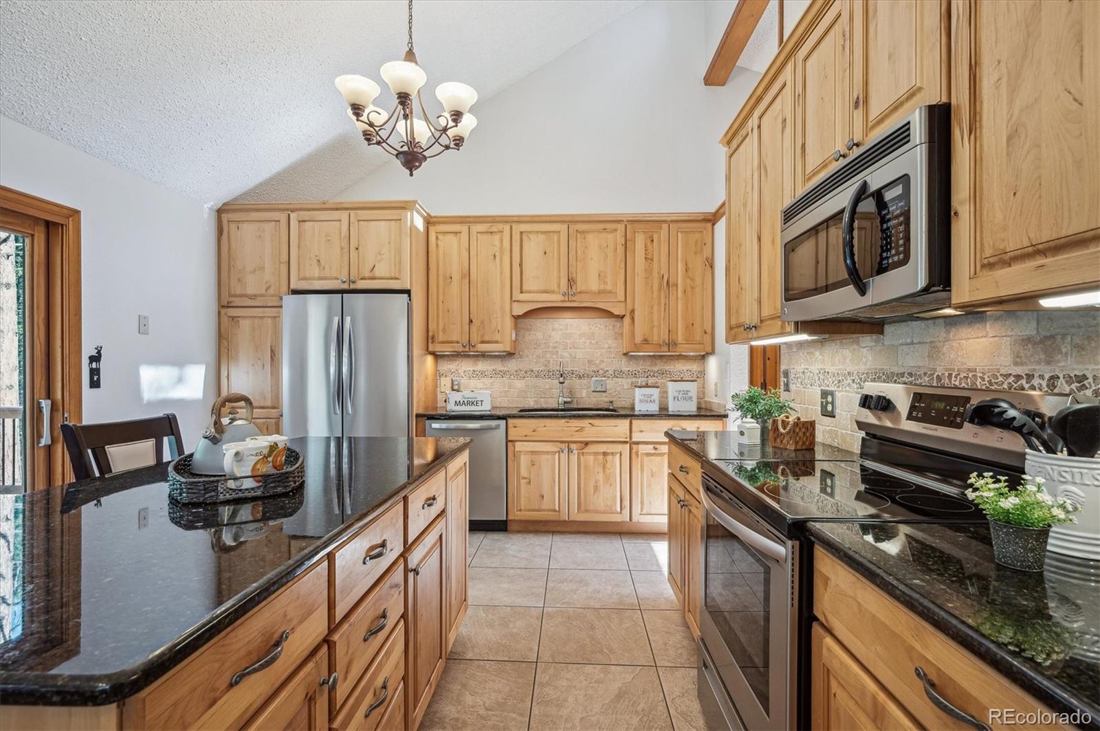 20025 Flint Lane Morrison, CO 80465 - Photo 8 of 35 a kitchen with stainless steel appliances granite countertop a sink stove and refrigerator