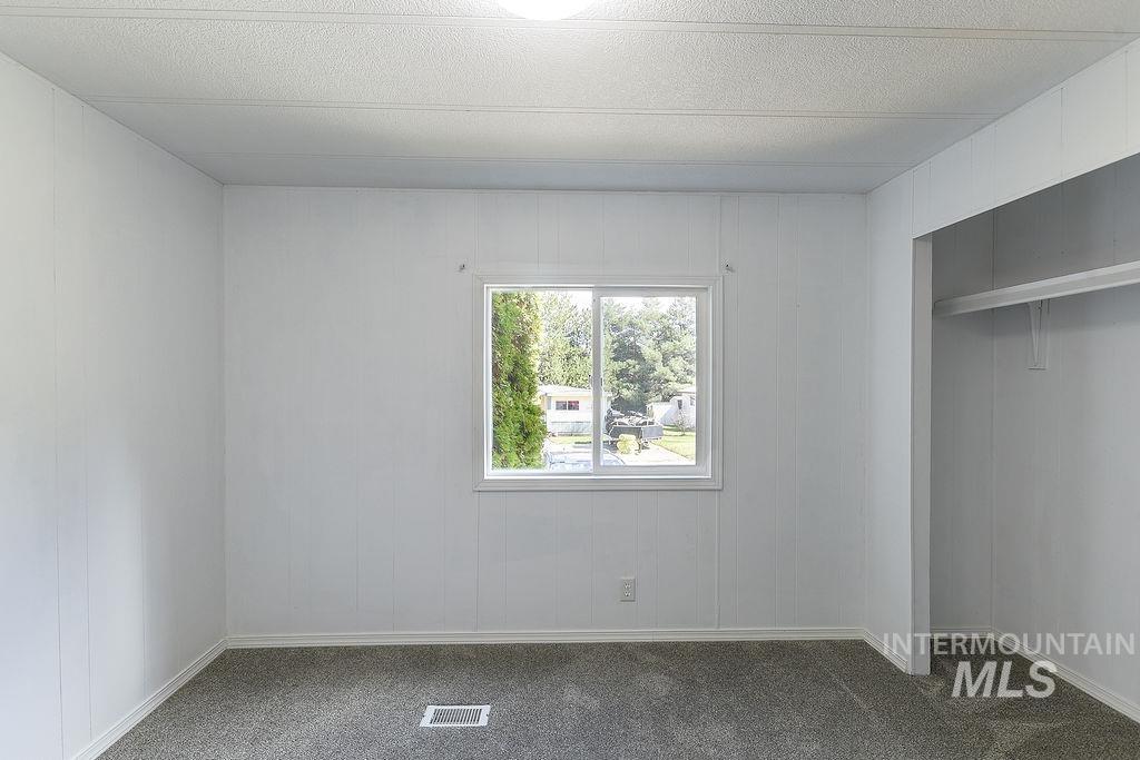 609 North Almon Street, Unit 2011 Moscow, ID 83843 - Photo 12 of 45 Unfurnished bedroom featuring a closet, carpet floors, and a textured ceiling