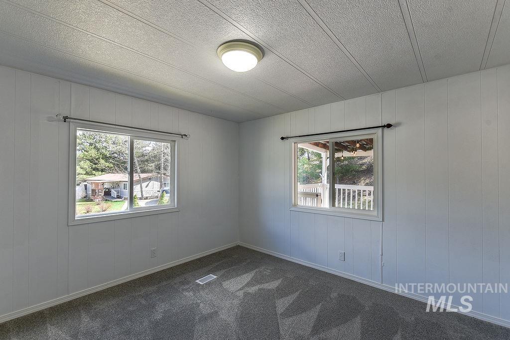 609 North Almon Street, Unit 2011 Moscow, ID 83843 - Photo 14 of 45 Unfurnished room with wood walls, a textured ceiling, and dark carpet