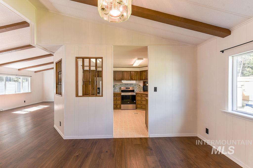 609 North Almon Street, Unit 2011 Moscow, ID 83843 - Photo 18 of 45 Kitchen with tasteful backsplash, electric stove, wood-type flooring, wood walls, and vaulted ceiling with beams