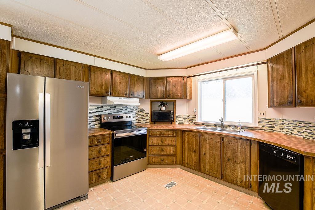 609 North Almon Street, Unit 2011 Moscow, ID 83843 - Photo 22 of 45 Kitchen featuring black appliances, decorative backsplash, and a textured ceiling