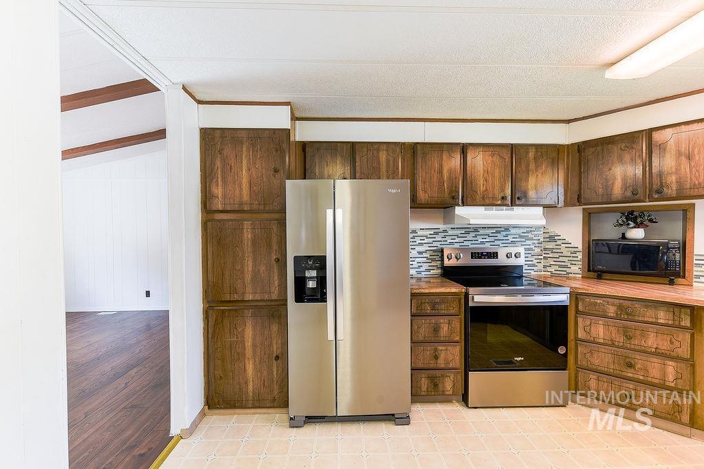 609 North Almon Street, Unit 2011 Moscow, ID 83843 - Photo 25 of 45 Kitchen featuring stainless steel appliances, tasteful backsplash, crown molding, dark wood finish cabinets, and wooden counters