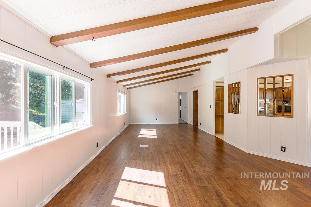 609 North Almon Street, Unit 2011 Moscow, ID 83843 - Photo 26 of 45 Unfurnished room with dark wood-style flooring, wooden walls, and vaulted ceiling with beams