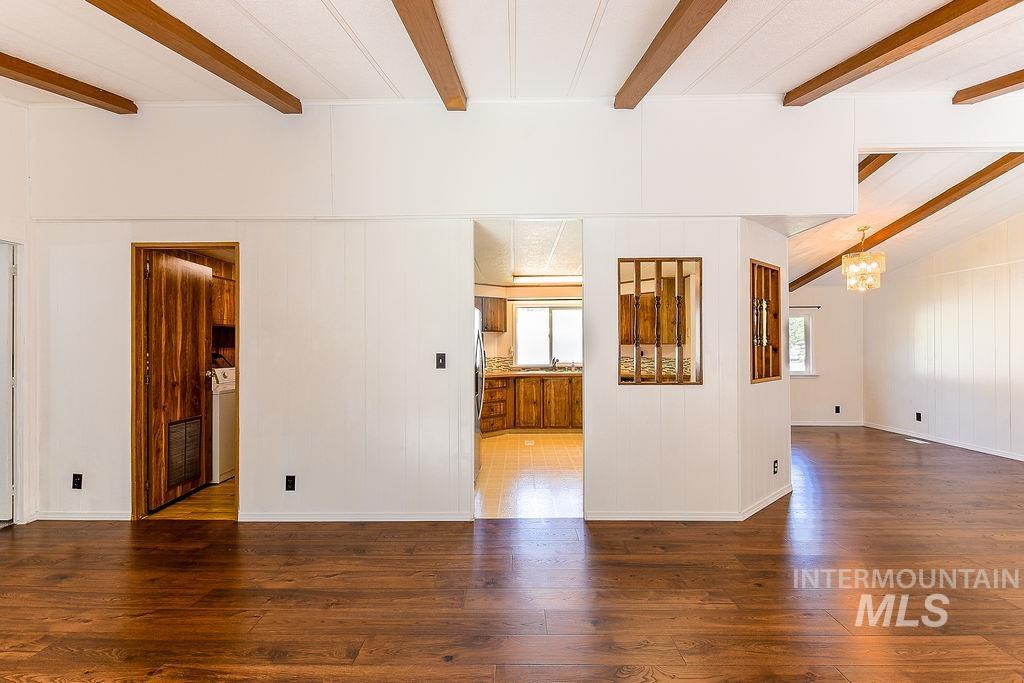 609 North Almon Street, Unit 2011 Moscow, ID 83843 - Photo 27 of 45 Unfurnished room featuring beam ceiling, dark wood-type flooring, hanging lights, and washer / dryer