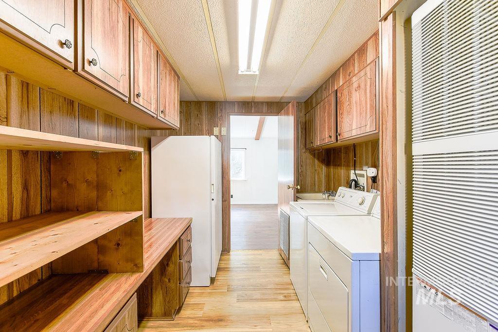 609 North Almon Street, Unit 2011 Moscow, ID 83843 - Photo 29 of 45 Laundry room with a heating unit, cabinet space, light wood-type flooring, wood walls, and washer and clothes dryer