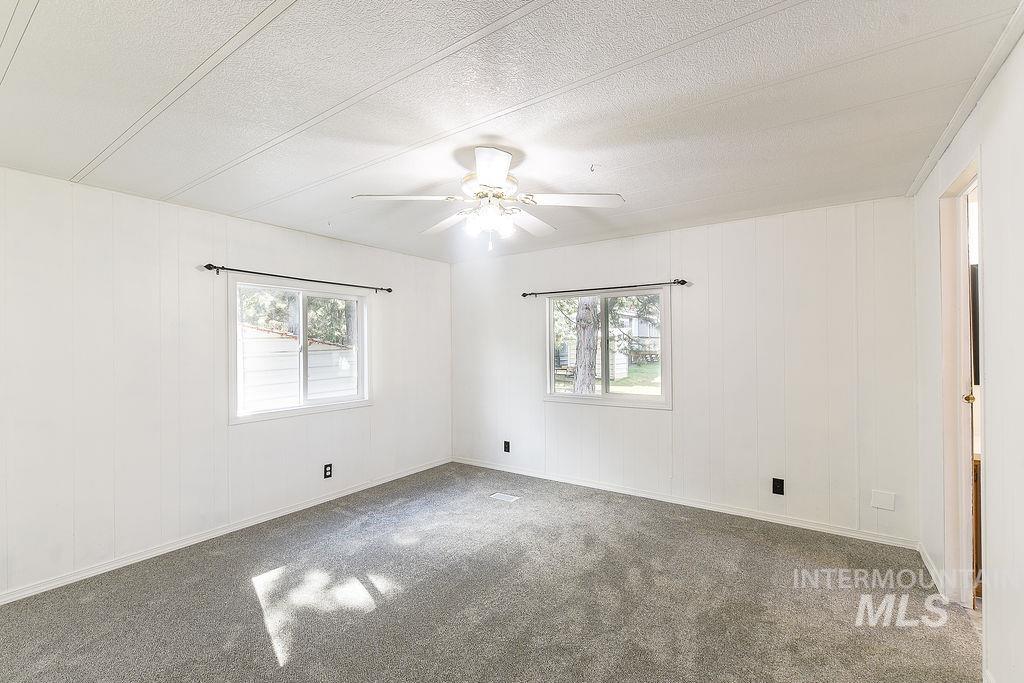 609 North Almon Street, Unit 2011 Moscow, ID 83843 - Photo 30 of 45 Unfurnished room with a ceiling fan, wood walls, carpet flooring, and a textured ceiling